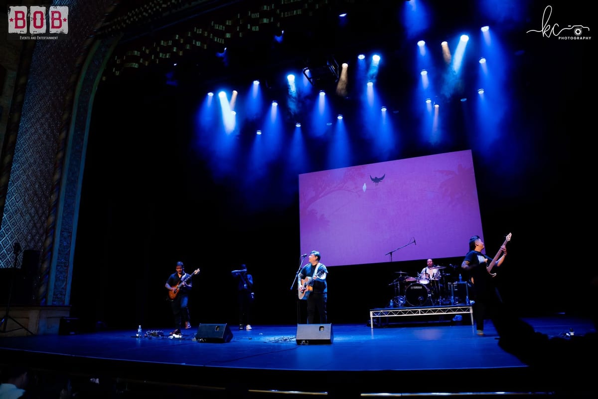 A band performing on stage with a purple backdrop screen at a B.O.B Events show
