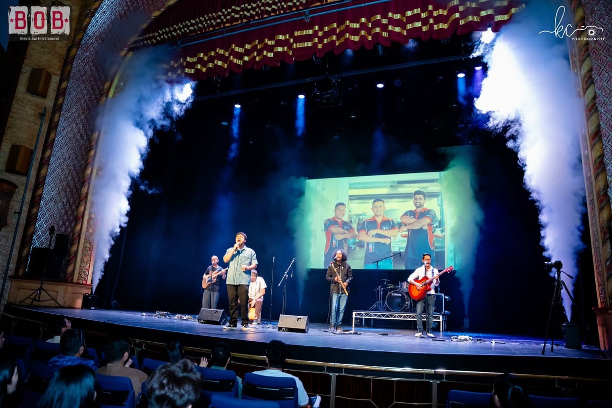 Cobweb performing on stage in smoke and stage lighting, with the crowd watching